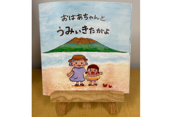 坂井研究室が鹿児島市方言による絵本『おばあちゃんとうみぃきたがよ』を発行しました